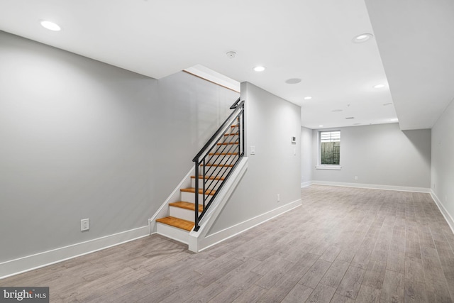 basement with wood finished floors, baseboards, stairway, and recessed lighting