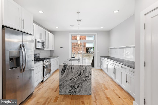 kitchen featuring stainless steel appliances, a sink, decorative backsplash, white cabinetry, and recessed lighting