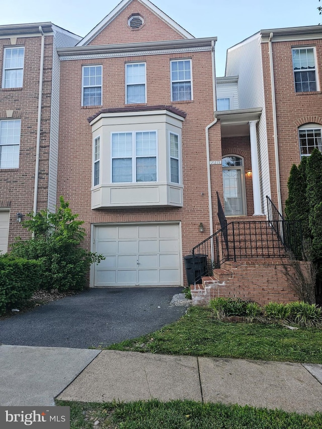 21219 Millwood Sq, Sterling, VA 20165 - multi unit property featuring driveway, brick siding, and an attached garage