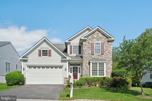 1723 Magnolia Ct, Garnet Valley, PA 19060 - view of front of home featuring stone siding, driveway, a garage, a front lawn, and central air condition unit