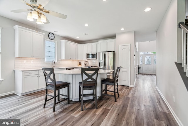 1723 Magnolia Ct, Garnet Valley, PA 19060 - kitchen featuring appliances with stainless steel finishes, light wood-type flooring, a kitchen bar, healthy amount of natural light, and recessed lighting