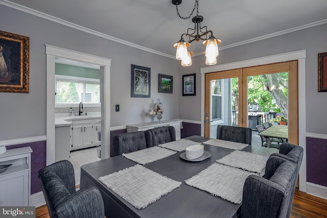 dining space featuring a chandelier, crown molding, and wood finished floors