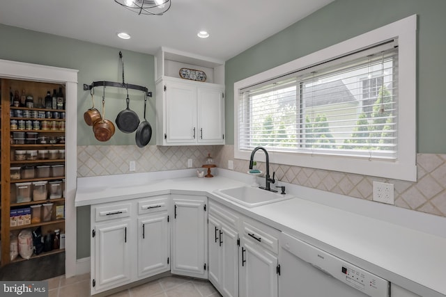 kitchen with a sink, white dishwasher, white cabinetry, tasteful backsplash, and recessed lighting