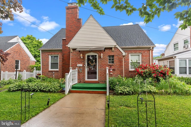 217 Lake Ave, Hamilton, NJ 08610 - tudor home with brick siding, roof with shingles, and a chimney