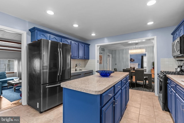217 Lake Ave, Hamilton, NJ 08610 - kitchen with stainless steel appliances, blue cabinets, a center island, backsplash, and light countertops
