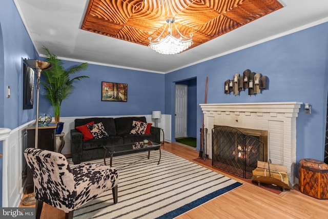 217 Lake Ave, Hamilton, NJ 08610 - living area with wood finished floors, a brick fireplace, a chandelier, and crown molding