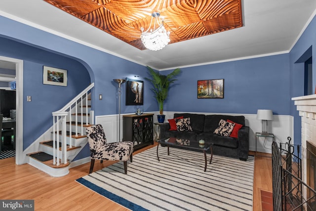 217 Lake Ave, Hamilton, NJ 08610 - living area featuring a brick fireplace, wood finished floors, stairway, arched walkways, and a wainscoted wall