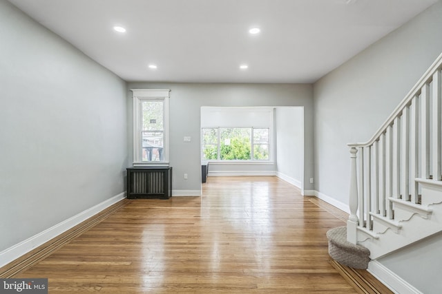 860 Foulkrod St, Philadelphia, PA 19124 - living room featuring wood finished floors, stairs, recessed lighting, baseboards, and radiator heating unit