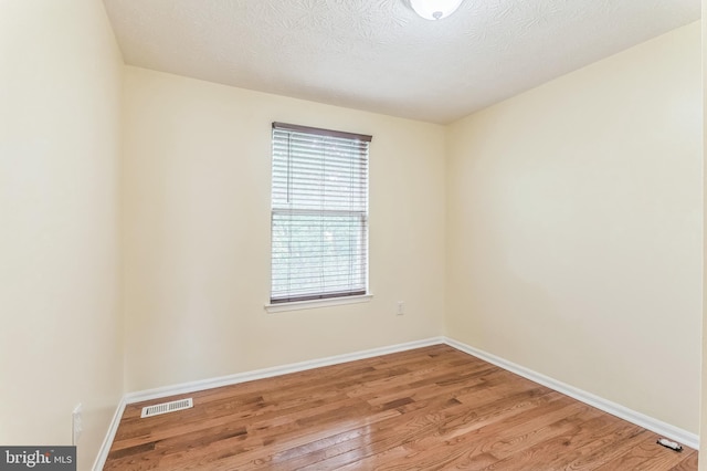 8151 Mandan Ter, Greenbelt, MD 20770 - unfurnished room with light wood-style flooring, baseboards, and a textured ceiling
