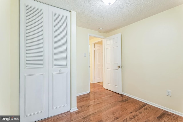 8151 Mandan Ter, Greenbelt, MD 20770 - unfurnished bedroom with a closet, light wood-style floors, baseboards, and a textured ceiling