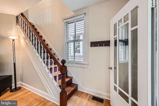 staircase with wood finished floors and baseboards
