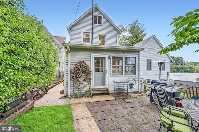 rear view of property featuring a patio, entry steps, and fence