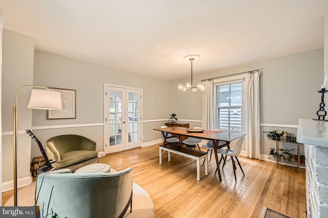 dining space featuring healthy amount of natural light, light wood-style floors, baseboards, and french doors