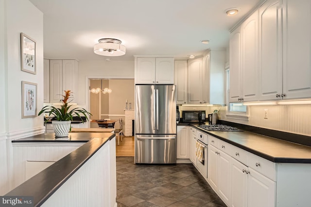kitchen with appliances with stainless steel finishes, dark countertops, white cabinets, and recessed lighting