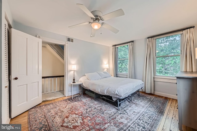 bedroom with wood finished floors, ceiling fan, and baseboards