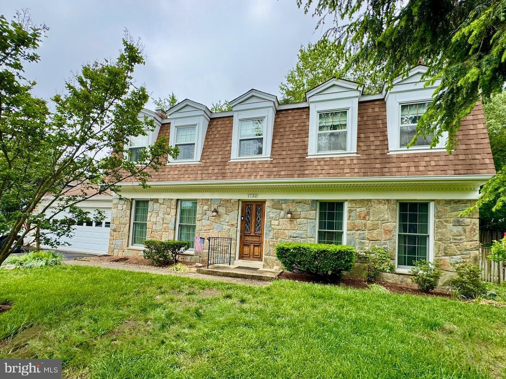 view of front facade featuring stone siding, roof with shingles, a front lawn, and an attached garage