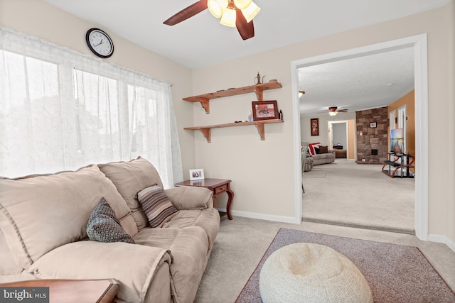 living room featuring ceiling fan, carpet, and baseboards