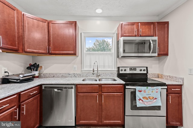 kitchen featuring stainless steel appliances, a sink, light stone counters, and ornamental molding