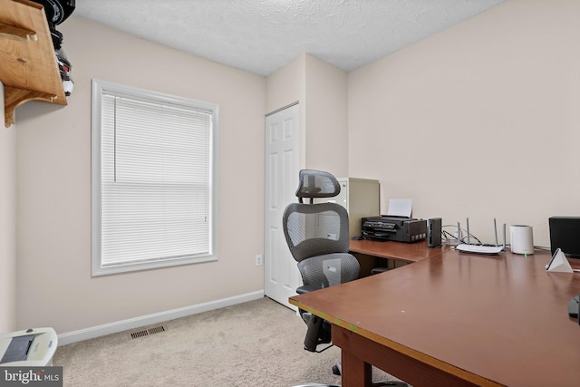 carpeted office featuring baseboards and a textured ceiling