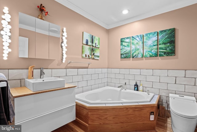 full bathroom featuring ornamental molding, tile walls, toilet, a garden tub, and vanity