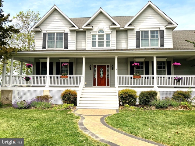 view of front facade with covered porch, a shingled roof, and a front lawn
