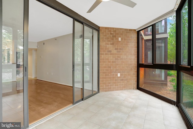 1001 N Randolph St Unit 109, Arlington, VA 22201 - unfurnished sunroom with a ceiling fan, brick wall, and a wall of windows