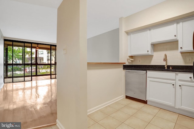 1001 N Randolph St Unit 109, Arlington, VA 22201 - kitchen featuring stainless steel dishwasher, decorative backsplash, white cabinetry, and baseboards