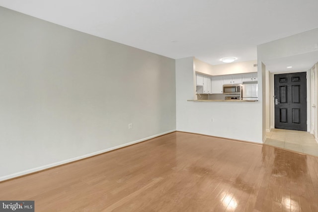 1001 N Randolph St Unit 109, Arlington, VA 22201 - unfurnished living room with light wood-type flooring and baseboards
