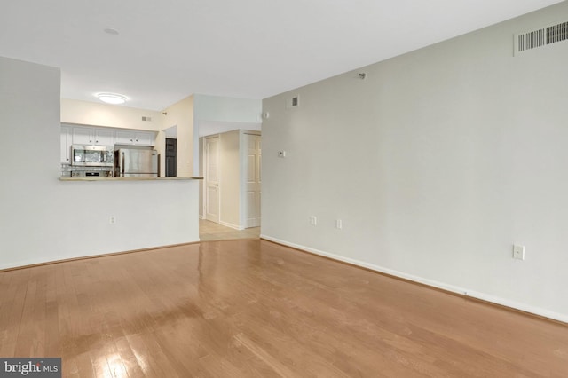 1001 N Randolph St Unit 109, Arlington, VA 22201 - unfurnished living room featuring light wood finished floors and baseboards