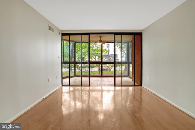 1001 N Randolph St Unit 109, Arlington, VA 22201 - spare room with expansive windows, wood finished floors, ceiling fan, and baseboards