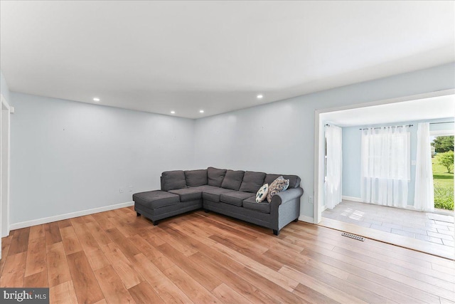 living room featuring light wood-style floors, recessed lighting, and baseboards
