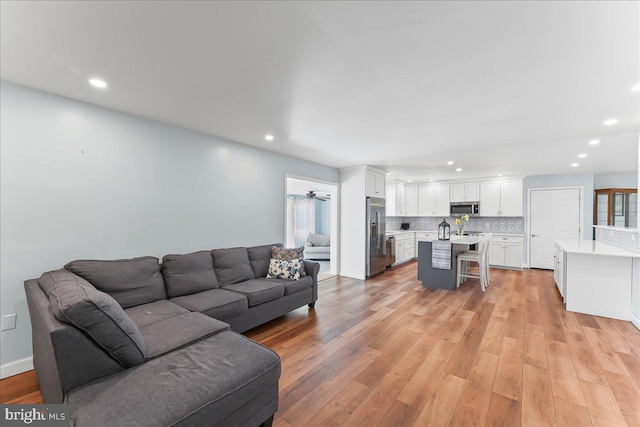 living area with recessed lighting and light wood finished floors