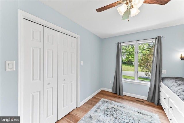unfurnished bedroom with a closet, light wood-type flooring, baseboards, and a ceiling fan