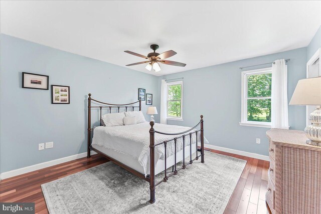 bedroom featuring wood finished floors, baseboards, and a ceiling fan