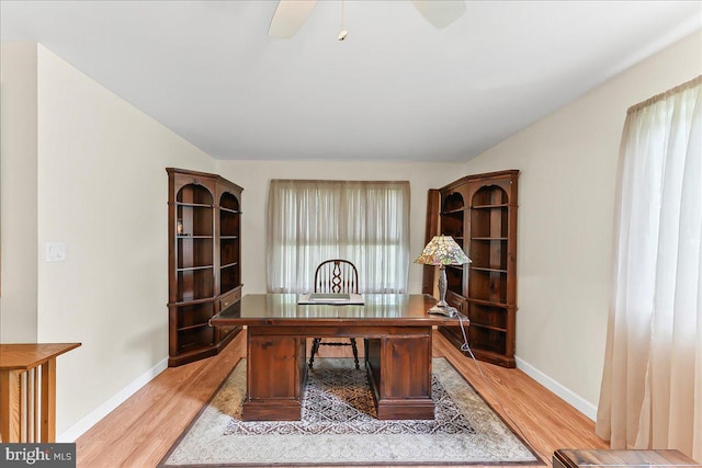 office space featuring light wood-type flooring, baseboards, and a ceiling fan