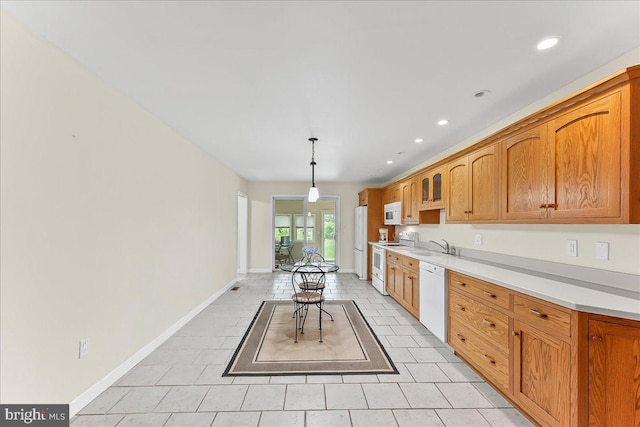 kitchen featuring white appliances, light countertops, baseboards, recessed lighting, and decorative light fixtures