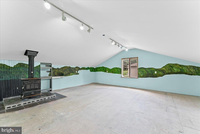 additional living space featuring a wood stove and vaulted ceiling