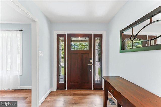 entryway with hardwood / wood-style floors and baseboards
