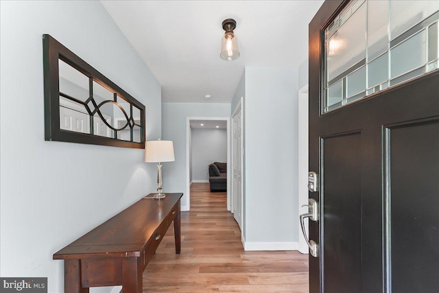 foyer featuring light wood-style floors and baseboards