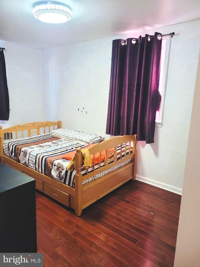 bedroom featuring wood-type flooring and baseboards