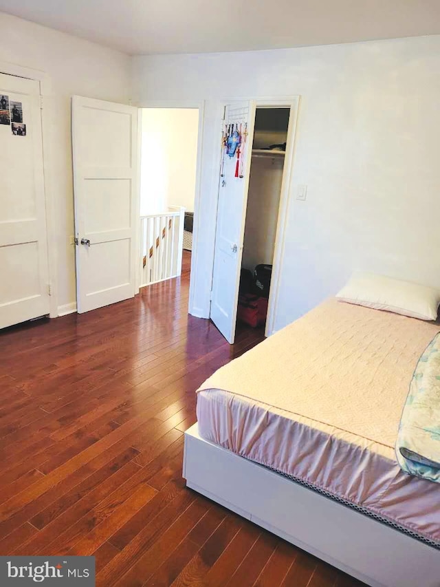 bedroom with dark wood-style flooring and a closet