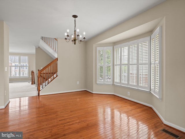 9757 Cheshire Ridge Cir, Manassas, VA 20110 - unfurnished room with stairway, hardwood / wood-style flooring, baseboards, and a chandelier