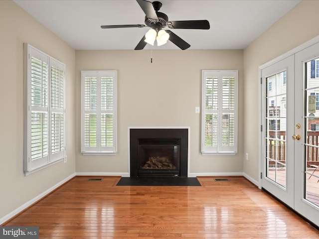 9757 Cheshire Ridge Cir, Manassas, VA 20110 - unfurnished living room with french doors, hardwood / wood-style floors, healthy amount of natural light, and a fireplace with flush hearth