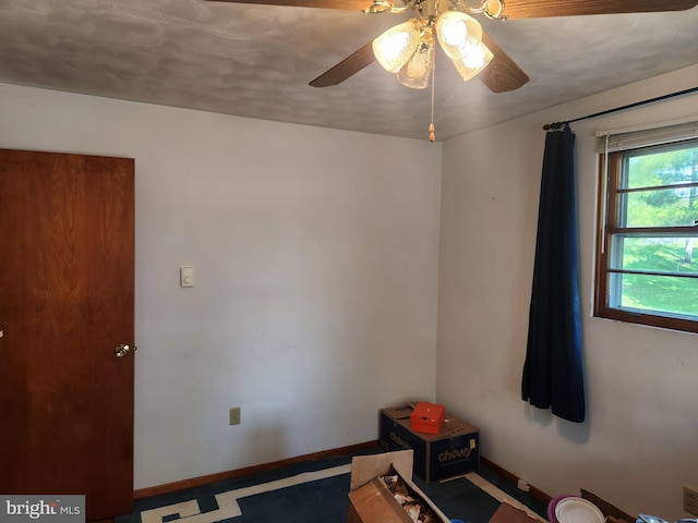 empty room with baseboards and a ceiling fan