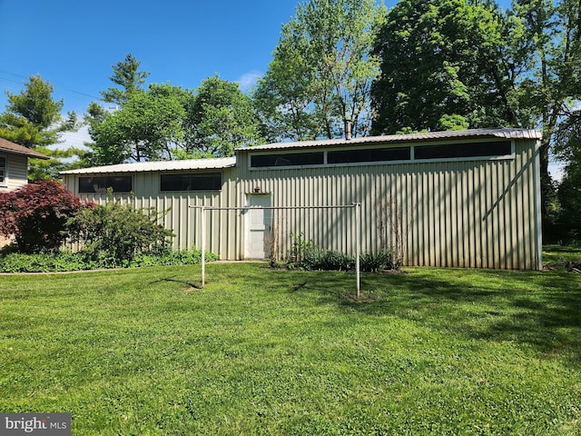 view of grassy yard with a pole building and an outbuilding