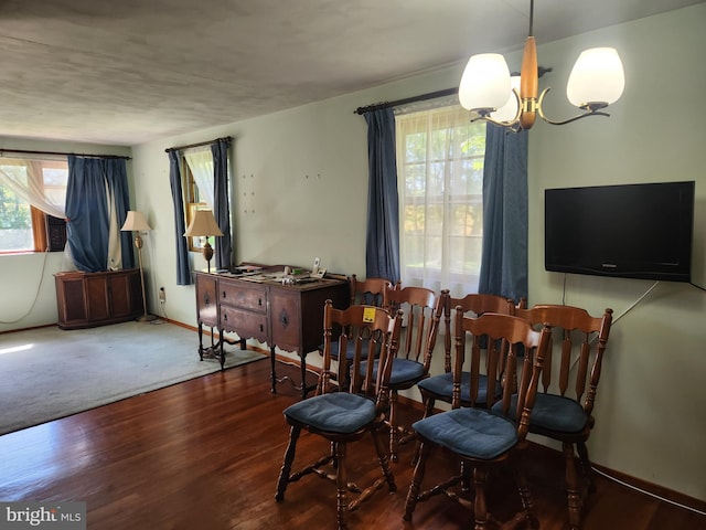 living area with a chandelier, wood finished floors, and baseboards