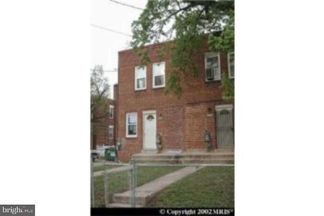 townhome / multi-family property with brick siding and fence
