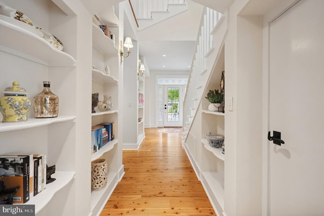 hall with light wood-style flooring, built in shelves, stairs, recessed lighting, and baseboards