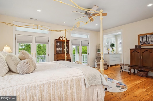 bedroom with french doors, access to outside, multiple windows, wood finished floors, and recessed lighting