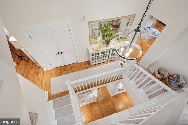 stairway with wood finished floors and baseboards